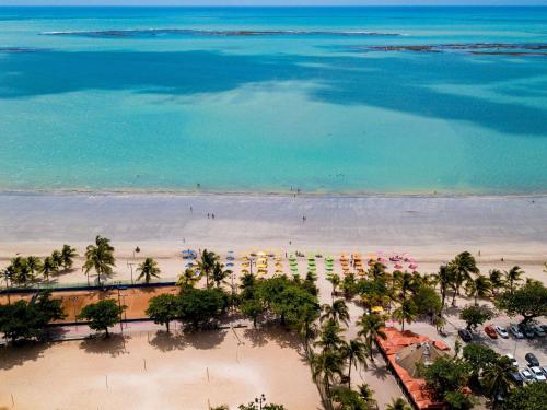 an aerial view of a beach with palm trees and the ocean at ibis budget Maceió Pajuçara in Maceió