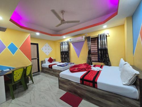 two beds in a room with colorful walls at Hotel JBL in kolkata