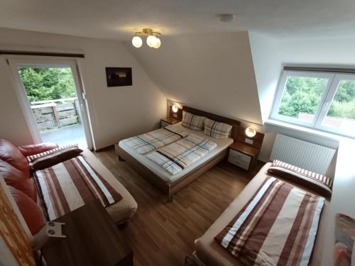 a bedroom with two beds and two windows at Ferienwohnung Michelle mit Balkon für 1 - 6 Personen in Warmensteinach