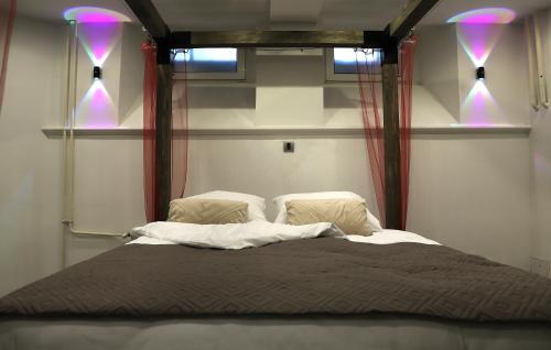a bedroom with a large bed with purple lights at Q-Art Hidden Garden City Centre in Novi Sad