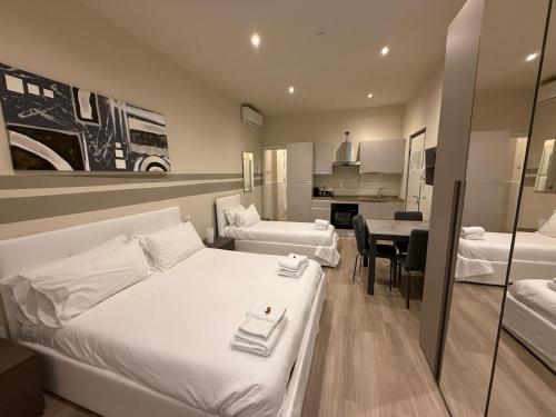a hotel room with two beds and a kitchen at City Loft in Piacenza