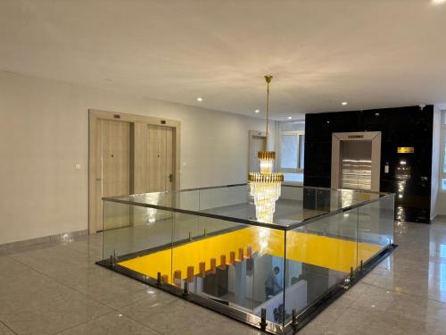 a glass table in a room with a yellow floor at Hotel Srirangasthalam in Chitradurga