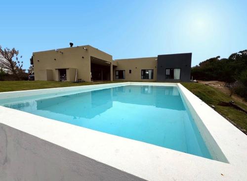 a swimming pool in front of a house at North beach Pinamar in Pinamar