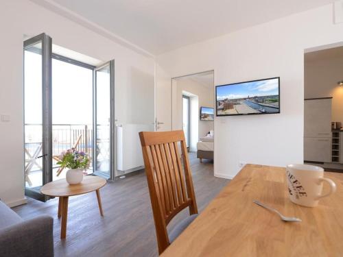 a dining room and living room with a table and a couch at Ohlerich Speicher App_ 27 in Wismar