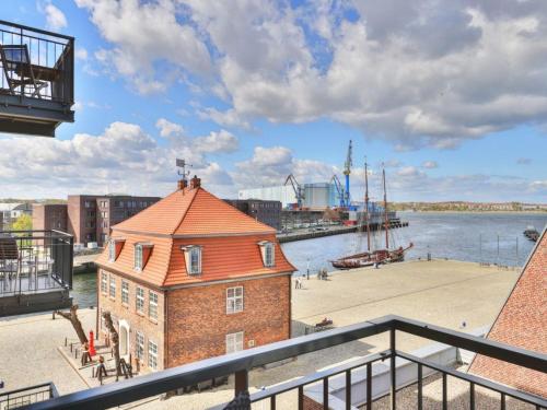 a brick building on the side of a body of water at Ohlerich Speicher App_ 20 in Wismar