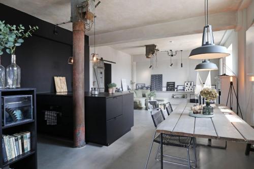 a kitchen and living room with a table and chairs at Ohlerich Speicher App_ 17 in Wismar