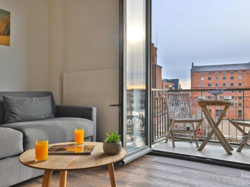 a living room with a couch and a table and a balcony at Ohlerich Speicher App_ 10 in Wismar