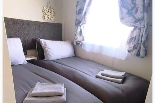 a bedroom with two beds and a window at StaticCaravan-6Berth-DogFriendly in Northampton