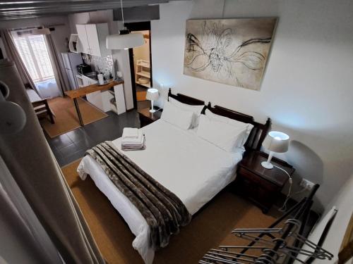 a bedroom with a bed with white sheets and pillows at Grace Walk Guest House in Swellendam