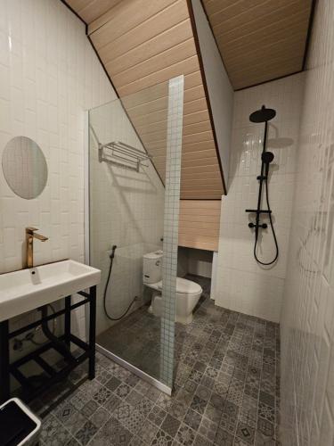 a bathroom with a shower and a toilet and a sink at Kala Senja Guest House in Sukawati