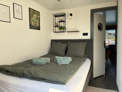 a bed in a room with two pillows on it at Houseboat De Amstel in Monnickendam