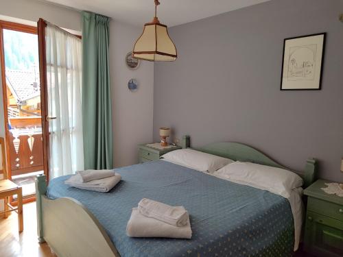 a bedroom with a bed with two towels on it at Appartamento Campitello House in Campitello di Fassa