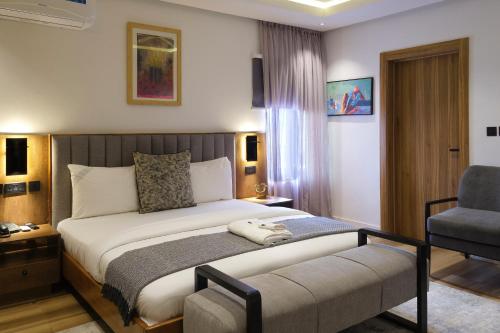a hotel room with a bed and a chair at Black Muse Residence in Benin City