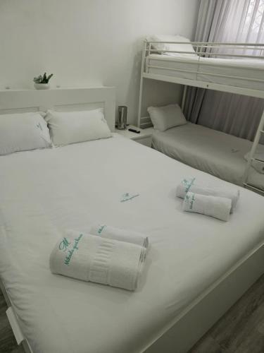 a white bed with two bunk beds in a room at Mikaela Guest House in Odivelas