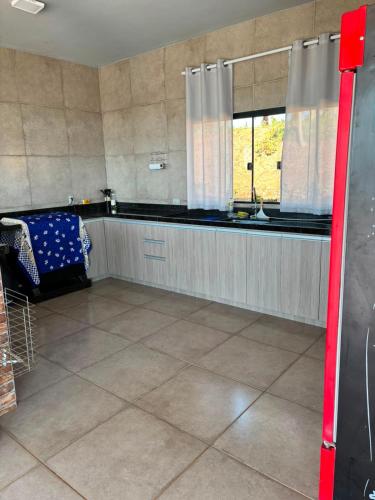 a large kitchen with a counter and a window at Rancho Bela Vista in Alexânia