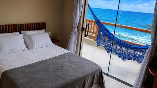 a bedroom with a bed and a view of the ocean at Fran de Fransquinha in Taíba