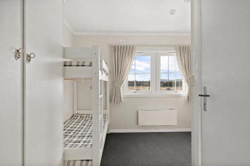 a room with a bunk bed and a window at Stølsdokken Lodge in Sanderstølen