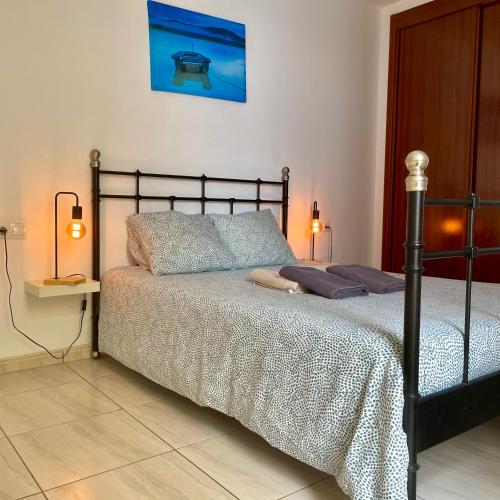 a bedroom with a bed and two lamps on a tiled floor at Casa Vega in El Cotillo