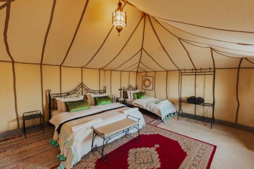 a bedroom with two beds in a tent at Kidal Luxury Camp in Adrouine