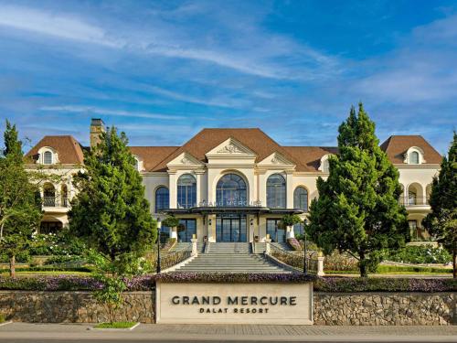 a large mansion with a sign in front of it at Grand Mercure Dalat in Da Lat