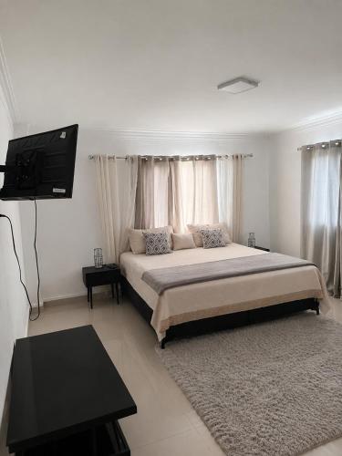 a bedroom with a bed and a flat screen tv at Vista al Caribe in La Francia