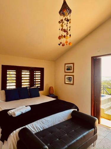a bedroom with a large bed and a chandelier at Wind Village in Itarema