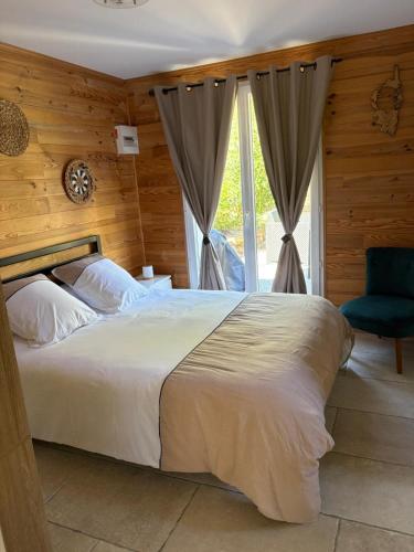 a bedroom with a large bed and a blue chair at Charmant chalet en montagne in Petreto-Bicchisano