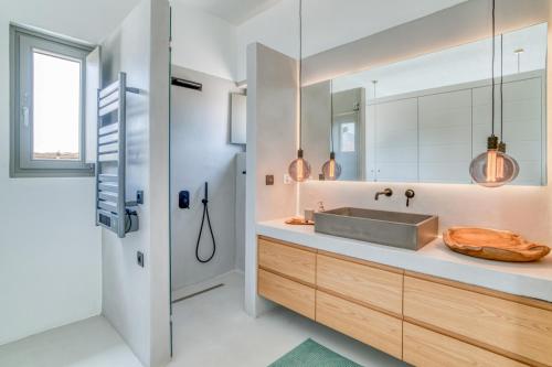 a bathroom with a sink and a mirror at Villa Ena - Beach getaway in Logaras