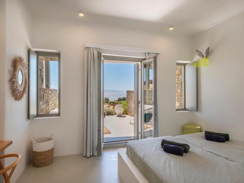 a bedroom with a bed and a door to a patio at Villa Ena - Beach getaway in Logaras