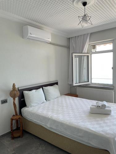 ein Schlafzimmer mit einem großen weißen Bett und einem Fenster in der Unterkunft Hisar Beach Hotel in Yaylacık