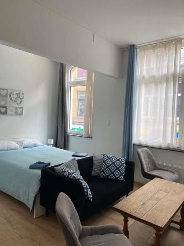 a bedroom with a bed and a couch and a table at Hébergement Citabelle in Dinant
