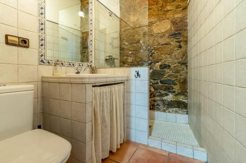 a bathroom with a toilet a sink and a shower at Casa rural rio yeguas in Azuel