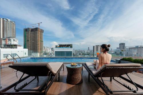 a woman sitting on the roof of a building at Yes Hotel Đà Nẵng in Danang
