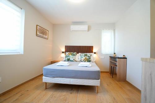 a bedroom with a bed and a desk in it at Studio S Les Suites Du Roubion in Montélimar
