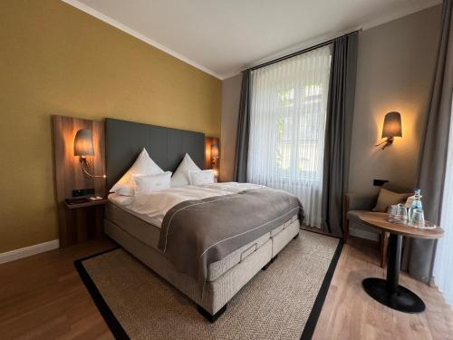 a bedroom with a large bed and a window at Boutique-Hotel Moseltor in Traben-Trarbach