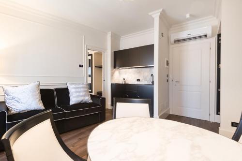 a living room with a black couch and a table at Verona House Aparthotel in Verona