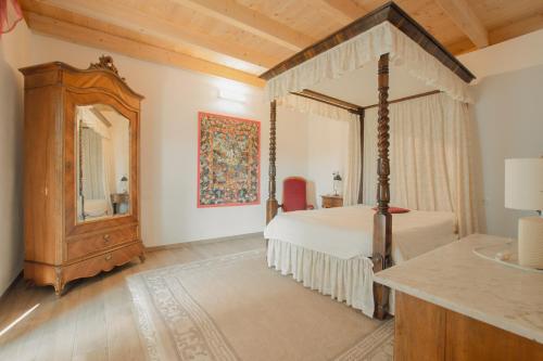 a bedroom with a canopy bed and a mirror at Residenza sul Lago Maggiore in Luino