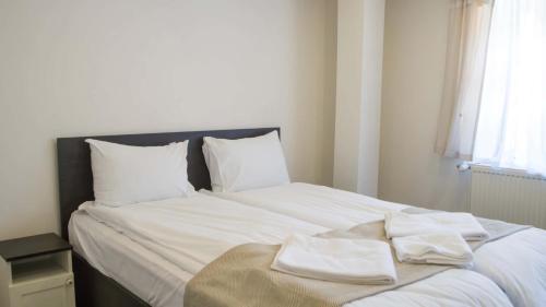 a white bed with white sheets and pillows on it at Бекяровата къща in Spasovtsi