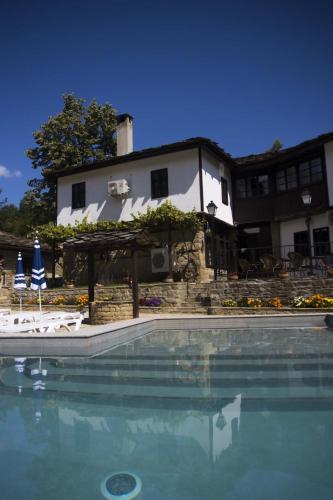 a swimming pool in front of a house at Бекяровата къща in Spasovtsi