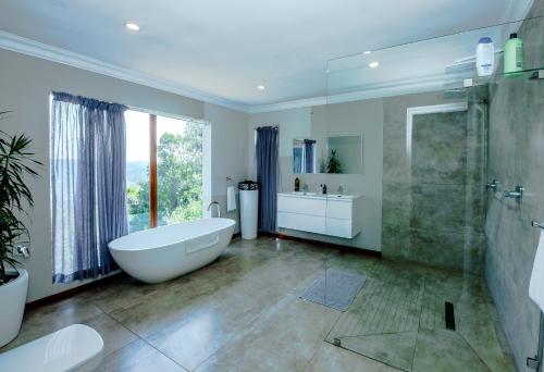 a bathroom with a tub and a shower and a sink at Crestwood Bed & Breakfast in Curryʼs Post