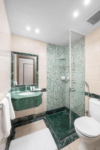 a bathroom with a tub and a sink and a toilet at Grand Millennium Al Haram Hotel in Medina