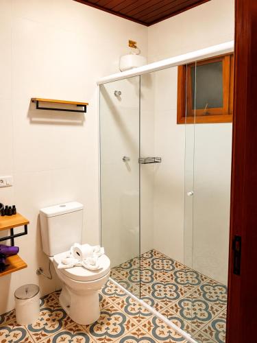 a bathroom with a toilet and a glass shower at Casa Garten by Concavus in Campos do Jordão