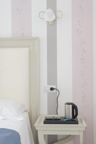 a bedside table with a lamp and a telephone at Gruppo Luxe Domus Vigevano in Vigevano