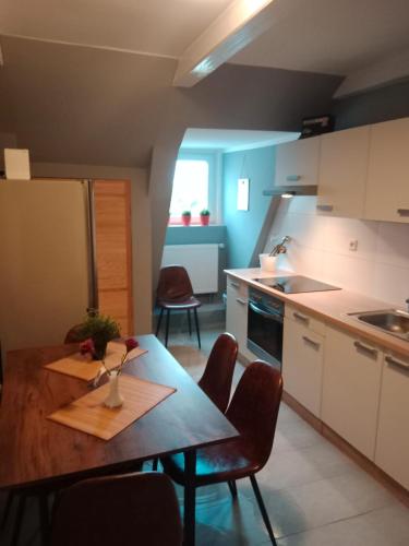 a kitchen with a table and chairs and a refrigerator at FördeFlats in Flensburg