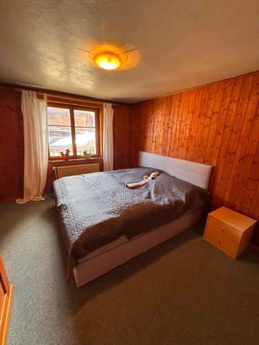 a bedroom with a large bed in a wooden wall at Appartement Grande Dixence - Hérémence in Hérémence