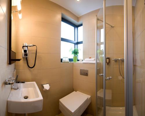 a bathroom with a toilet sink and a shower at Design Hotel Zollamt in Kaiserslautern