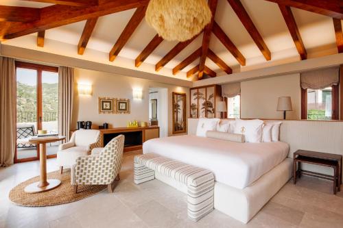 a bedroom with a large white bed and a couch at Gran Hotel Margalida by Annua Signature in Banyalbufar