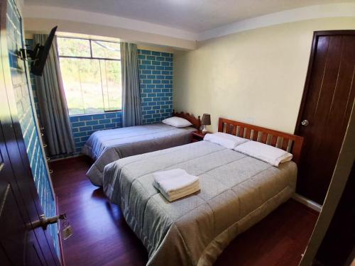 a hotel room with two beds and a window at Fundo San Silvestre in Huaraz