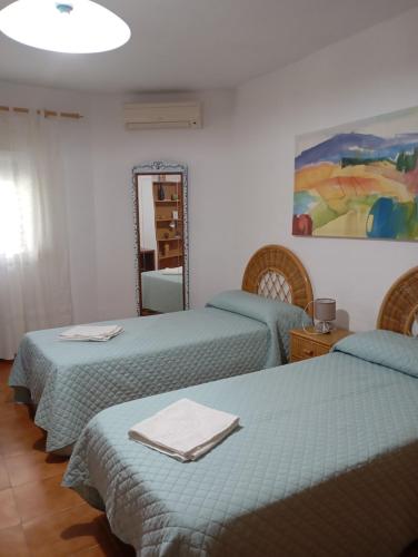 a room with three beds and a mirror at Casa La Vega in Torrox Costa