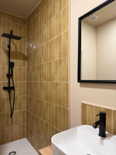 a bathroom with a sink and a shower with a mirror at Casa Limón in Bodonal de la Sierra